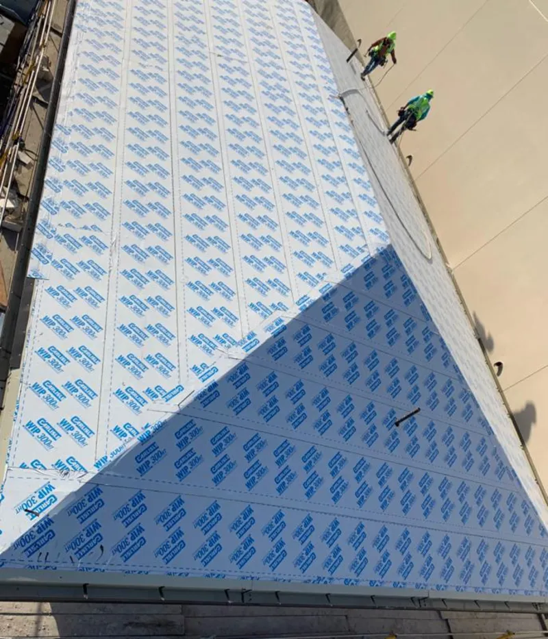 Professional roofers installing underlayment on a metal roof in Somerset